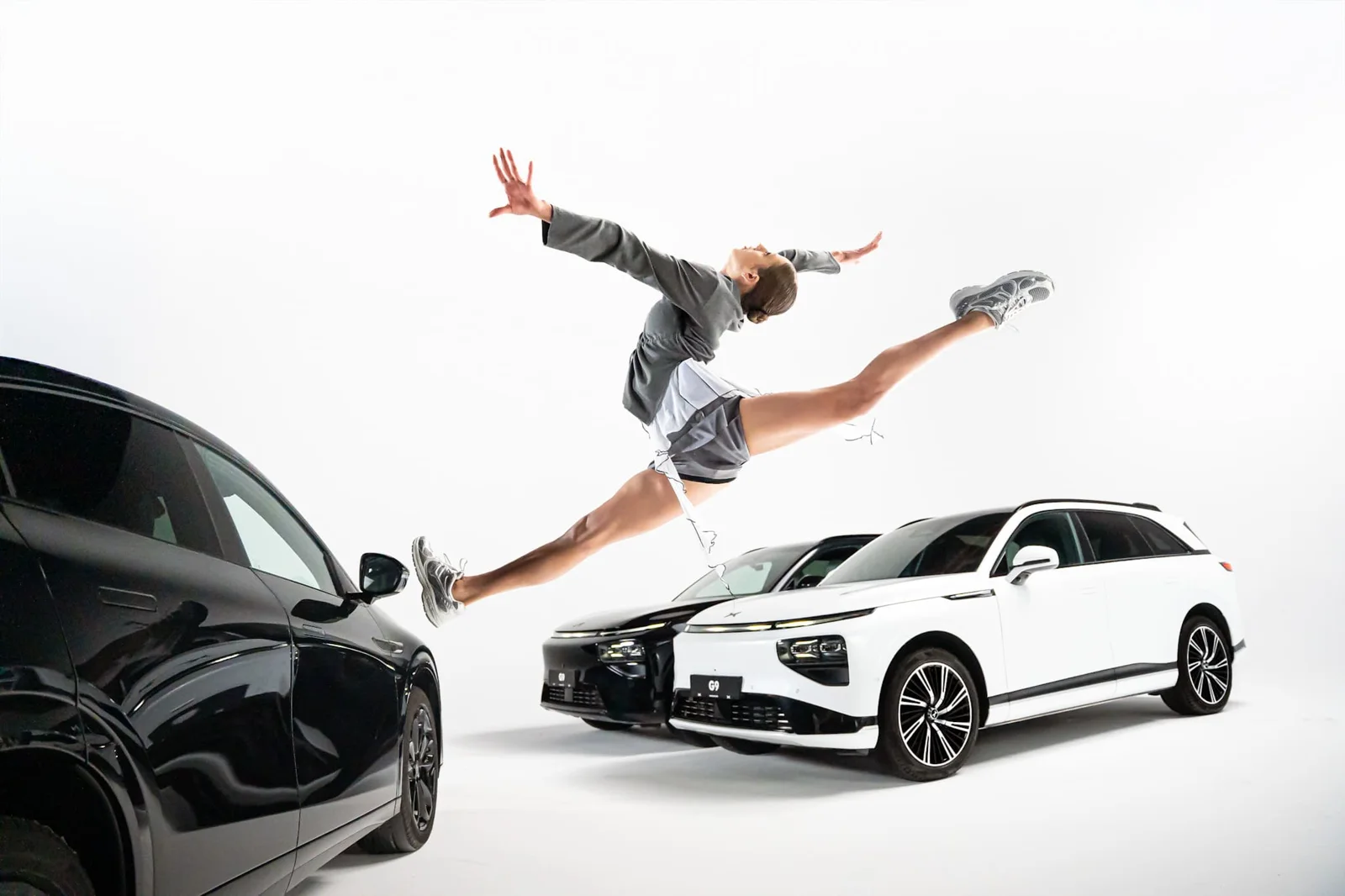 Athletin zwischen XPENG Fahrzeugen im Studio